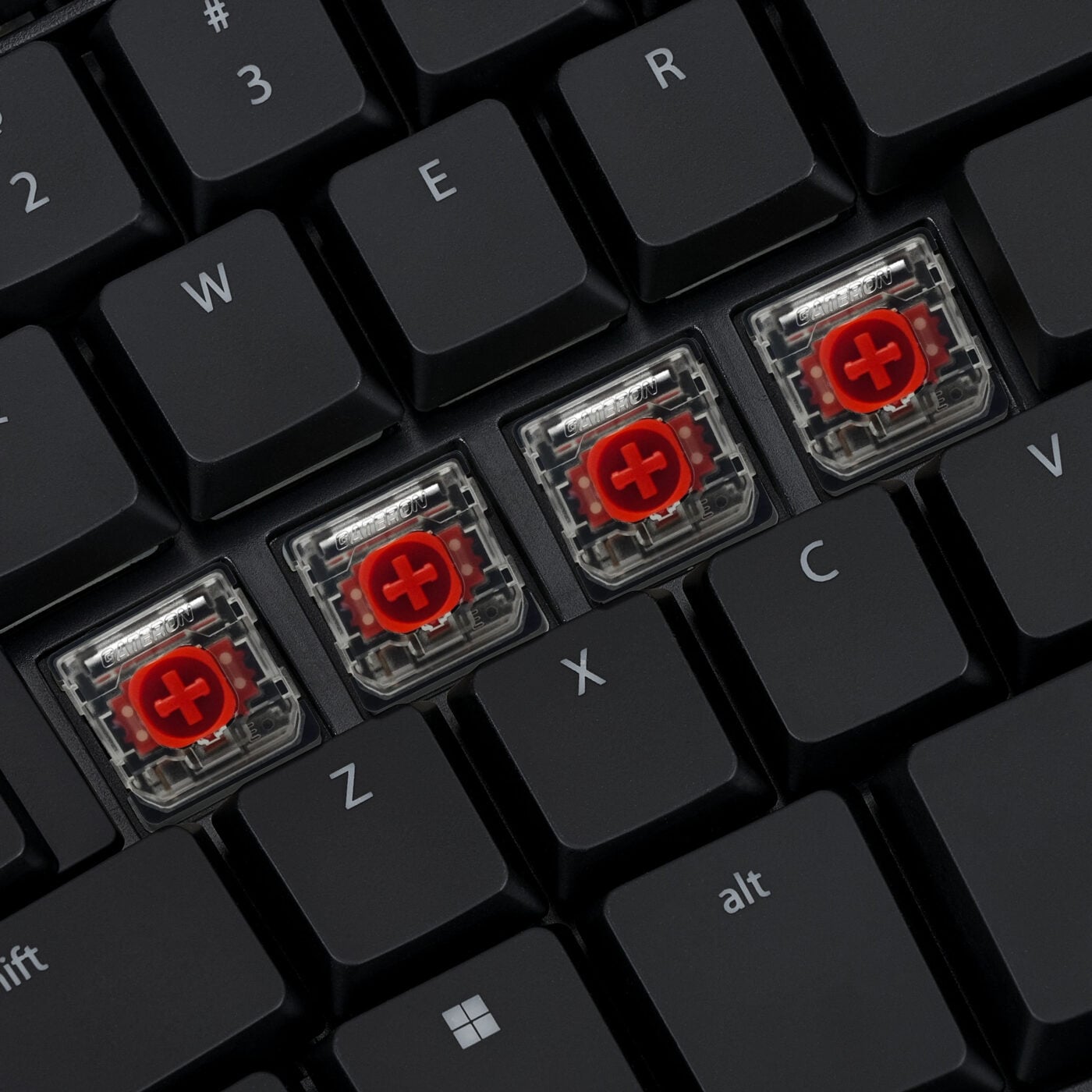 Mechanical keyboard close-up showing red switches under removed keycaps. Ideal for gaming enthusiasts and typists.